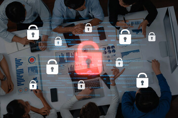 A group of professionals collaborates around a laptop, emphasizing cybersecurity in an office setting, with padlock icons representing data protection and analysis. Trope