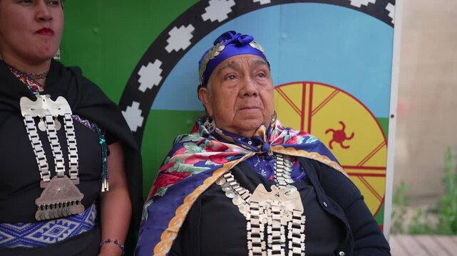 Older mapuche woman wearing a trarilonco on her head and traditional silver jewelry