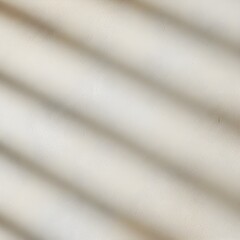 Fototapeta premium Soft diagonal shadow lines cast across a neutral textured wall, creating a subtle abstract pattern.
