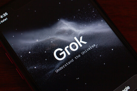 Quito, ECUADOR - Jan 13 2026 : Close-up of a smartphone showing the Grok AI launch screen with cosmic background and tagline "Understand the Universe."