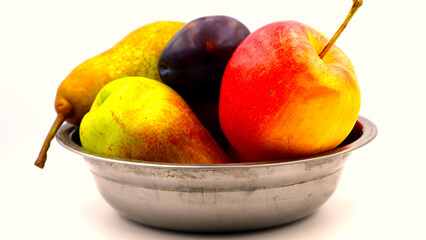 Colorful fresh fruits in a metal bowl on white background.