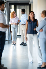 Fototapeta premium Business professionals networking and discussing ideas in modern office hallway
