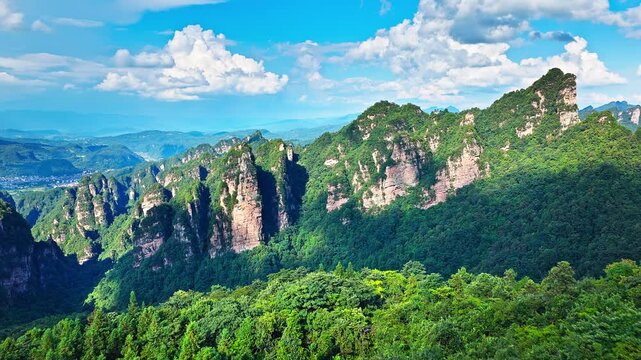 Aerial shot of spectacular sandstone pillar and high mountain peak with lush green forest natural landscape in summer. Famous Zhangjiajie National Forest Park in Hunan, China. 