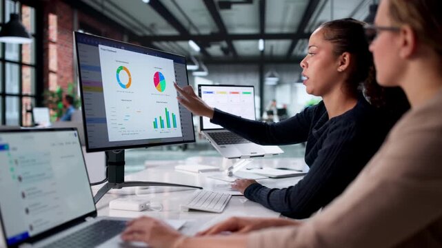 Women Looking At Computer Data Heatmap