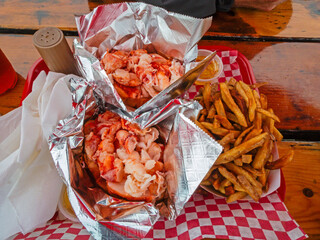 Fresh Lobster Rolls and fries on a picnic table in Wiscasset, ME, in early summer
