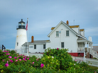 Pemaquid Point Lighthouse in Bristol ME on an early summer day in June with fresh flowers and lush foliage