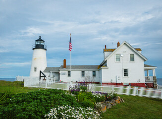 Pemaquid Point Lighthouse in Bristol ME on an early summer day in June with fresh flowers and lush foliage