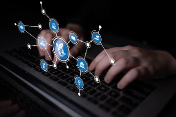 Hands typing on a laptop keyboard with digital connection icons around, illustrating modern networking and online collaboration in a dark environment. Tessel
