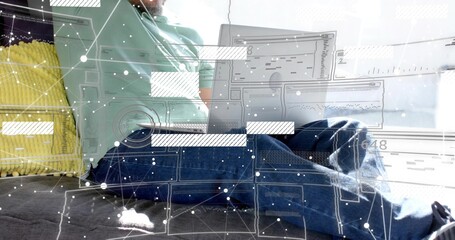 Working man wearing light green polo and jeans on bed with laptop, yellow cushion, digital overlay