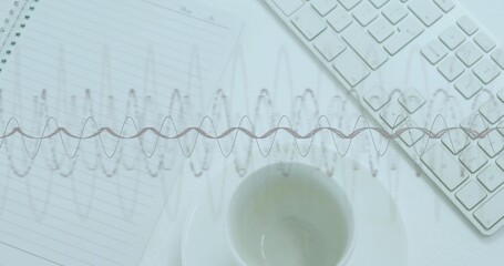 Showing ceramic cup and saucer sitting centered lower at desk, with waveform, notebook, keyboard