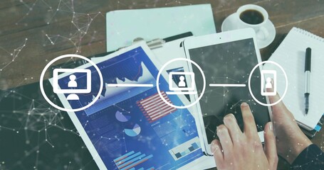 Operating tablet, phone at wooden desk, analyst in dark sleeves, showing charts, folder, net icons