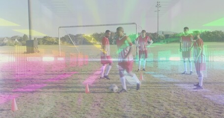 Dribbling player with soccer ball among five adult male teammates wearing red bibs on grass field