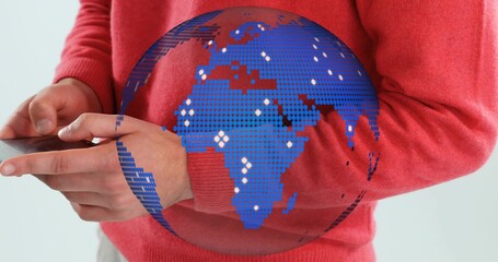 Tapping adult male wearing red sweater holding tablet against plain grey wall, with globe overlay