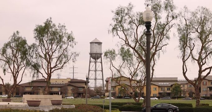 An old water tower stands above homes in a residential district of Chino, California, USA.