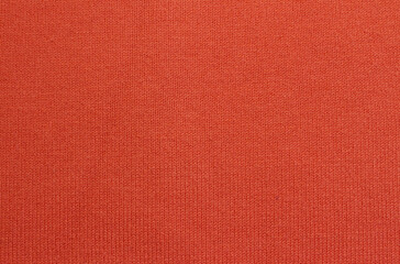 Fototapeta premium Close-up orange knitted texture background. Orange knitted sweater made of cotton, acryl, and nylon blended yarn.