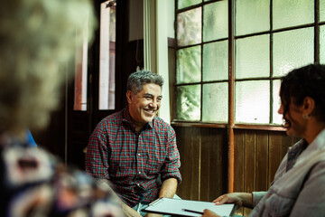 Smiling middle-aged man in group therapy meeting at community center