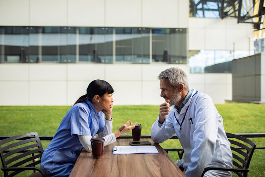 Healthcare professionals discussing case outdoors at hospital