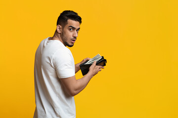 Finance, investment and money saving, unexpected income concept. Shocked middle eastern young guy...