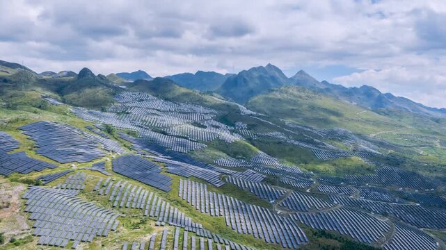 Aerial time-lapse of a vast solar farm on mountain slopes, rows of photovoltaic panels under dynamic clouds, scenarios of resource utilization in rocky desertification mountain areas
