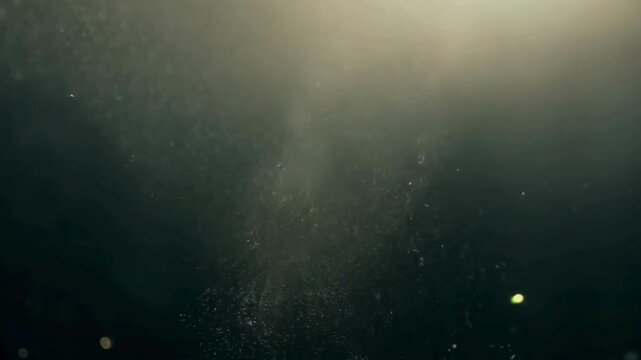 Floating Dust Particles in Light Beam. Cinematic atmospheric background with specks of dust drifting in a sun ray against a dark backdrop.