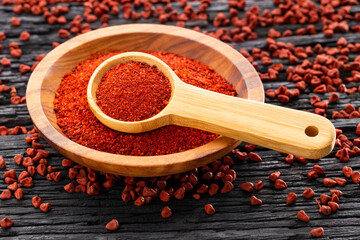 Crushed annatto seeds in the spoon and in the bowl - Bixa Orellana