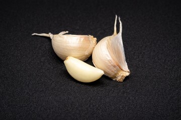 Fresh Garlic Cloves, Peeled and Unpeeled, Isolated on Dark Background