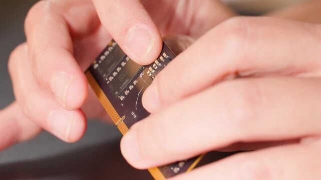 Hands Bending a Flexible Printed Circuit Board with Integrated Microchips