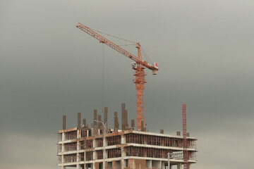 Towering Crane on Construction Site With Overcast Sky as Background