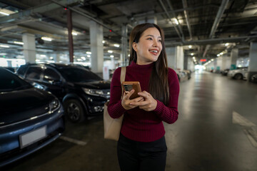 Woman smiling using smartphone in parking garage