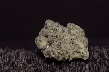 Studio close-up of medical cannabis flower and preparation details, including texture and plant material processing, presented in controlled lighting for healthcare, research, and alternative medicine