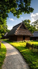 A rustic pathway meanders toward wooden structures with thatched roofs, embraced by lush greenery beneath a sunny, sky