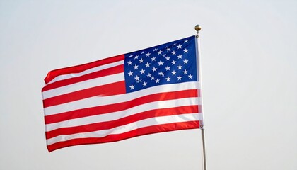 Fototapeta premium American flag waving proudly against a bright sky, symbolizing patriotism and national identity.