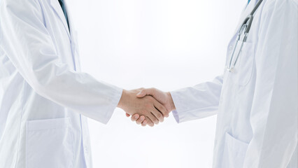 Fototapeta premium two doctors shaking hands professional medical collaboration agreement