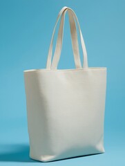 The stylish cream tote bag isolated on powder blue background. Fashion accessory, shopping bag, reusable, casual style, simple design, product photography, retail item.