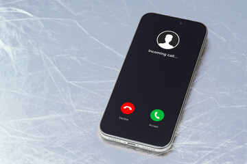 Modern smartphone lying on a light surface displaying an incoming call screen. Concept of mobile communication, digital notification, phone call alert and user interface design.