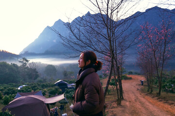 A Thai female tourist is standing and watching the sunrise at Doi Luang Chiang Dao, Chiang Mai Province, Thailand.