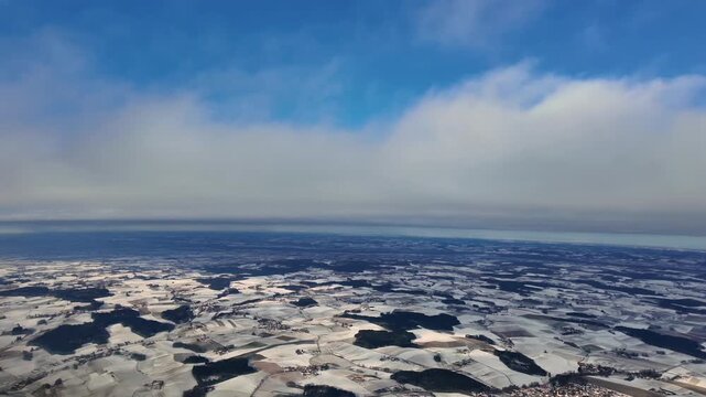 An immersive pilot&rsquo;s eye view from inside a jet cockpit doing the approach to Munich airport (MUC) in a cold winter day, with snow-covered landscape, flying under a layer of stratus clouds.