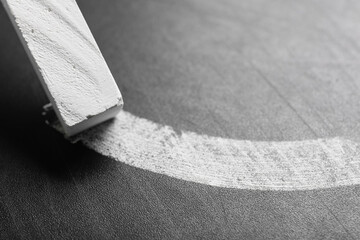 White chalk with drawn line on blackboard, closeup