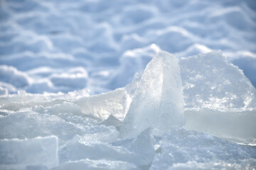 Close-up of fractured ice chunks glistening in bright sunlight on a cold winter day