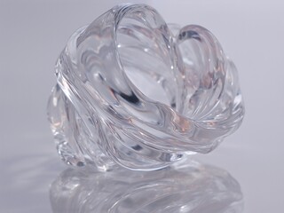 Clear Twisted Glass Sculpture with Reflections on Grey Surface