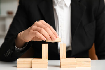 Female mediator stacking blocks at table in office, closeup