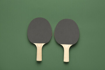 Black ping pong rackets on green background