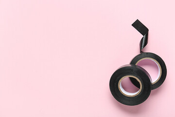 Black insulating tape rolls on pink background