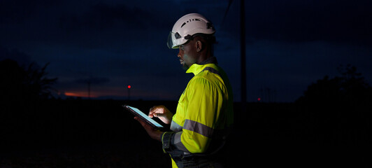 Technicians and engineers are working at a wind power plant at sunset. Renewable energy solutions to address climate change; clean energy at wind farms.
