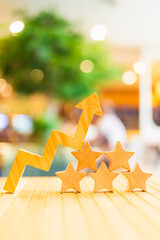 Rising arrow with wooden star icons representing increasing customer satisfaction, positive...