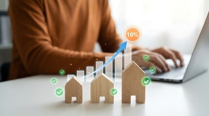 Person analyzing real estate market growth on laptop with wooden house models and graph showing 10% increase, symbolizing business success and investment strategy