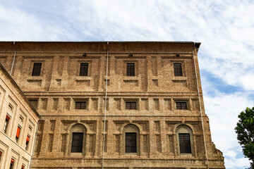 Low angle view of the majestic Palace featuring historical brick architecture and windows under cloudy sky