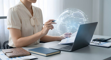 businesswoman analyzing global market data with holographic digital world globe and financial charts on laptop in modern office setting for international business concepts