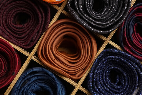 Box with different stylish ties as background
