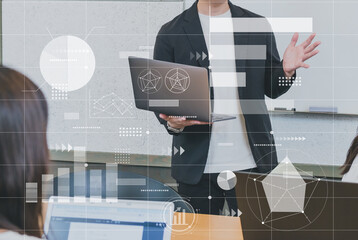 ノートパソコンを持ちプレゼンテーションを行うビジネスパーソン